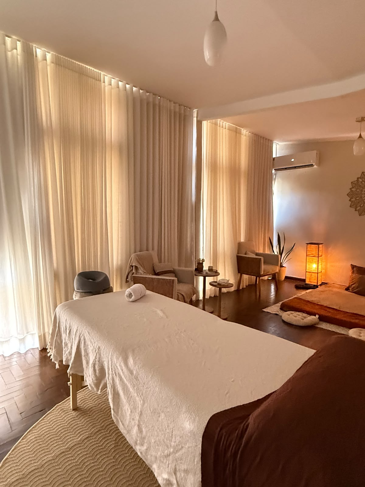 Sala ampla de massagem com maca e luz natural